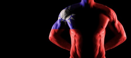 Taiwan flag on muscled male torso with abs, black background