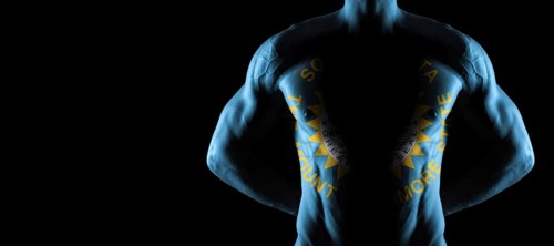 South Dakota flag on muscled male torso with abs, South Dakota bodybuilding concept, black