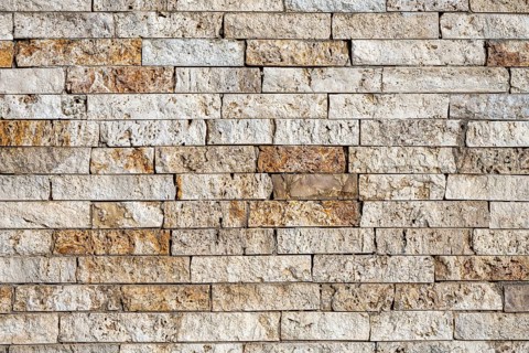 Background consisting of a wall of beige and brown clinker bricks