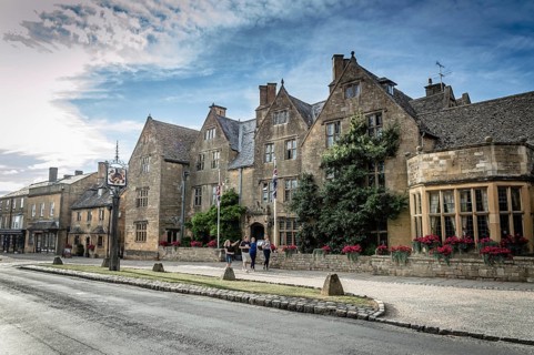 Broadway, UK, August 12, 2015: Main street of Broadway with typical limestone buildings with the
