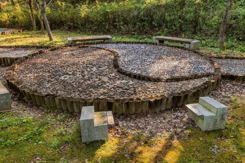 Yin yang symbol made of wooden posts and cemented rocks in wilderness park, Gongju, South Korea,