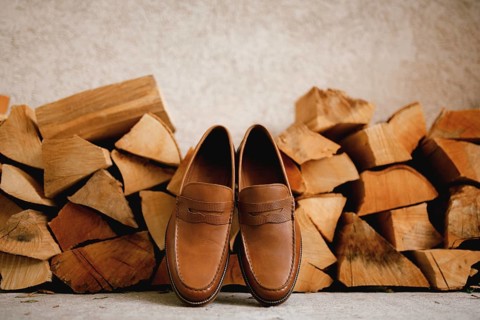 Brown men's shoes Penny loafers at the wood logs for the firebox.