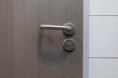 A stylish door handle rests on a beautiful wooden surface, perfectly showcasing modern design and