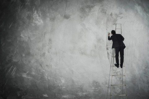 Männer zeichnen auf leere graue Wand