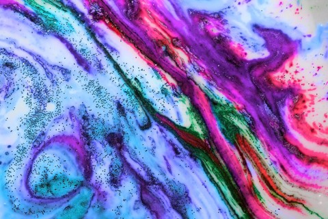 Multicoloured background of bright colours covered with gold sparkles
