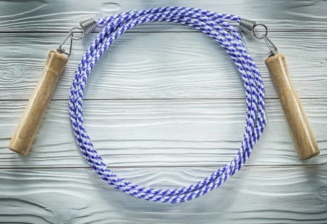 Jumping rope with wooden handles on wood board sports training concept