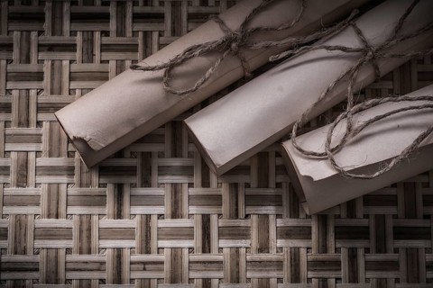 Vintage rolled scrolls on woven wooden mat