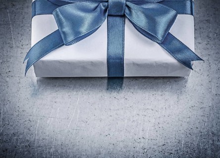Present box with blue ribbon on metallic background celebrations concept