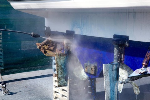 Pressure washer cleaning boat hull barnacles antifouling and seaweed