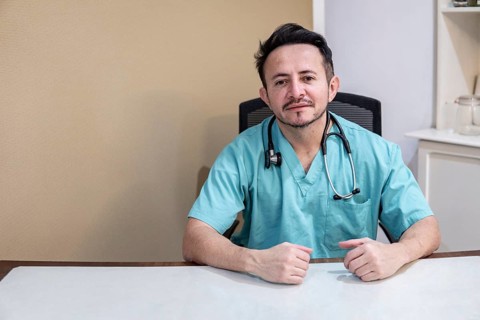 Portrait of a Latino doctor sitting at his desk