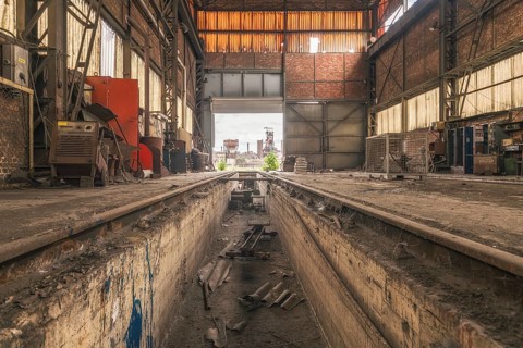 Old abandoned workshop with rails in the centre, numerous tools and rusty walls, steelworks HF4,