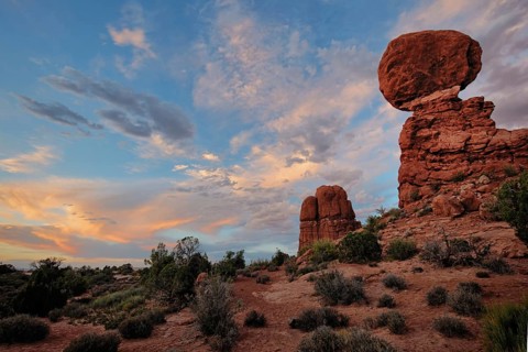 A colorful sunset glows over Balanced Rock, Arches National Park, Utah, USA, North America