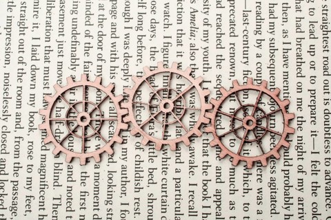 Wooden cogwheels on a page of a book. Industry concept information