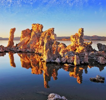 Orange sunset. The magic of Mono Lake. Outliers - calcareous tufa formation on the smooth water of
