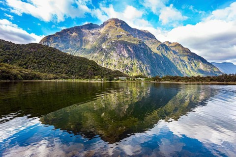 The mountains are reflected in the smooth water of the fjord. The most famous and picturesque fjord