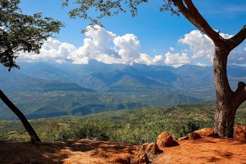 Panoramic view from Barichara, Colombia over green landscape to mountains with blue sky and white