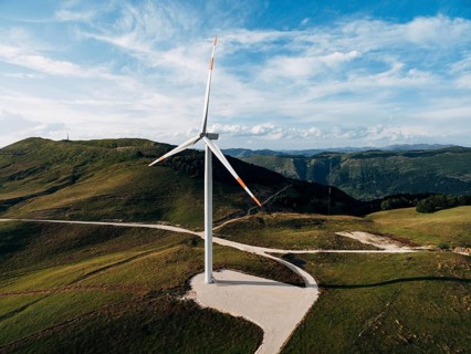 Beautiful bright photo of the wind generator in the field with the road.