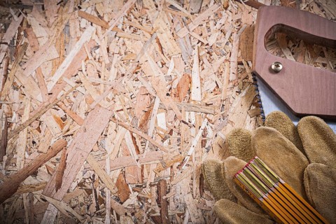 Protective leather gloves wooden meter handsaw on OSB