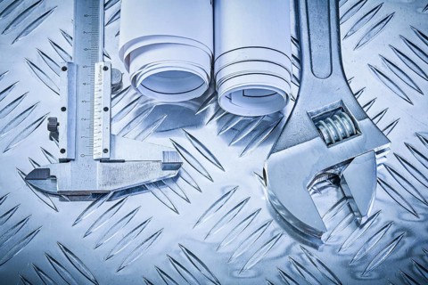 Construction plans vernier caliper adjustable wrench on grooved metal sheet maintenance concept