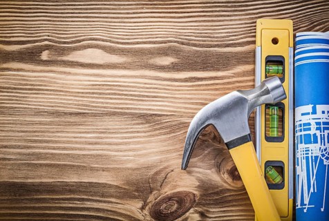 Construction level plan claw hammer on vintage wooden board copy space