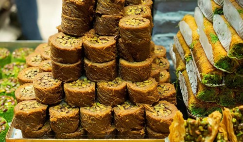 Turkish traditional dessert Kadayif baked in syrup served with nut powder
