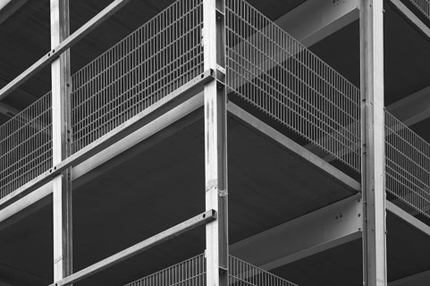 Architectural detail of a modern building highlighting steel beams and metal grids, creating a