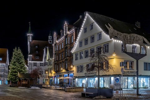 Night shot of historic buildings around the market square with Christmas tree, Biberach donkey, new
