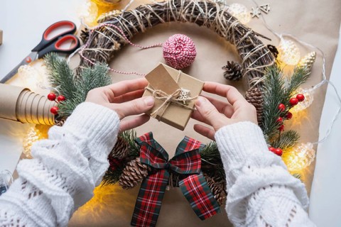 Pack a gift for Christmas and new year in kraft paper, cones, tape, scissors. Tags with mock up,