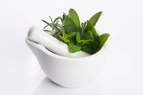 Mortar with herbs isolated on a white background