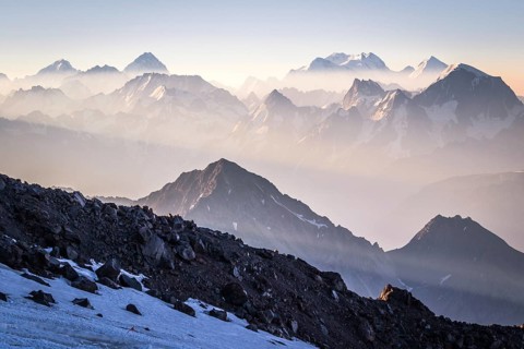 Sunrise in mountains enveloped by sun rays and mist