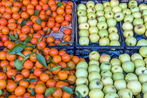 Green apples and mandarins for sale at a market