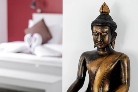 Bronze buddha statue interior design detail in modern asian home living room