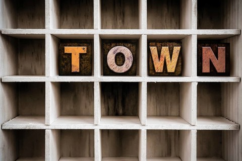 The word TOWN written in vintage ink stained wooden letterpress type in a partitioned printer's