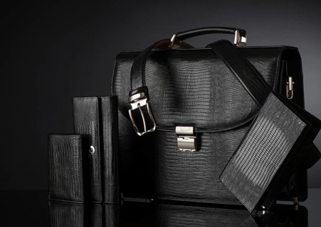 Fashionable men's set of leather accessories on a dark background. Briefcase, wallet, belt
