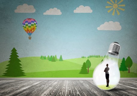 Businesswoman inside light bulb in room against nature drawn concept
