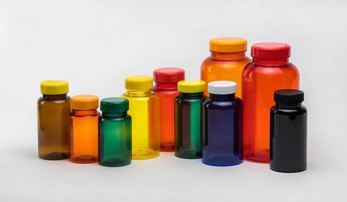 Multi colored transparent plastic pill jars on a white background. Isolated