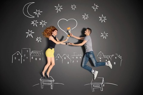 Happy valentines love story concept of a romantic couple standing on a stool and painting a heart