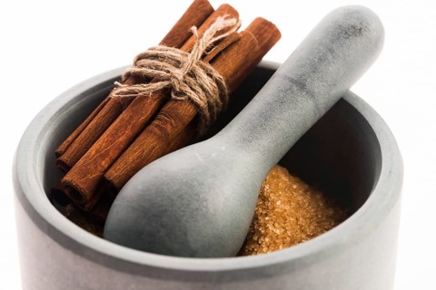 Cinnamon sticks with pure cane brown sugar in mortar