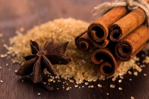 Cinnamon sticks with pure cane brown sugar on wood background