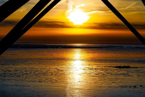 Sunset over the mudflats with dramatic colours and silhouettes in the foreground, Dorum-Neufeld