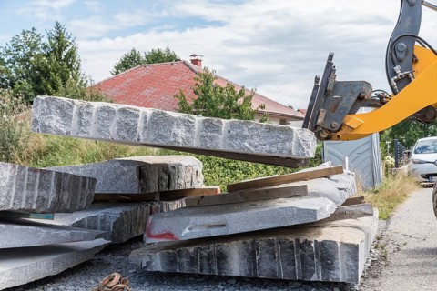 Transporting natural stone granite with a wheel loader - Front loader on construction site