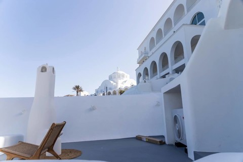 Deckchair on a viewpoint of a hotel complex, white buildings, orthodox cathedral in the background,
