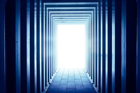 Line-shaped corridors leading to unknown bright exit door