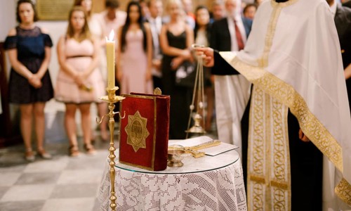 Wedding ceremony in an Orthodox church. The priest in a white cassock stand in the church at the
