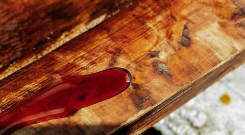 Close-up of wood stained red, emphasizing grain and texture