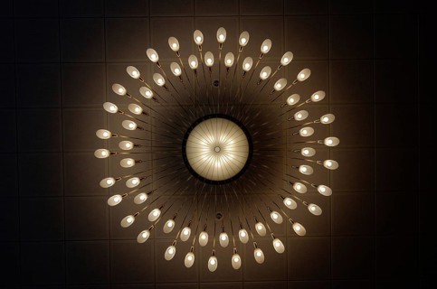 Large luxurious chandelier with burning bulbs seen from below