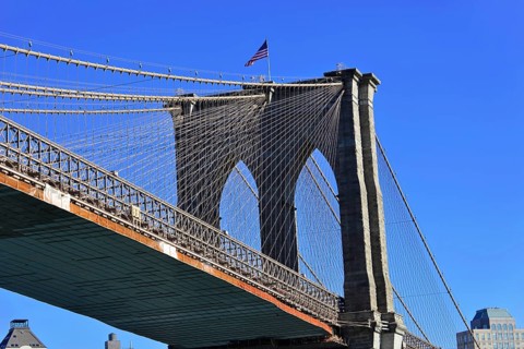 Brooklyn Bridge in Brooklyn, Manhattan, New York, section of a bridge with waving American flag and