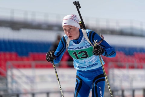 Sportsman biathlete Protasov Dmitry skiing on ski track distance biathlon stadium during Junior