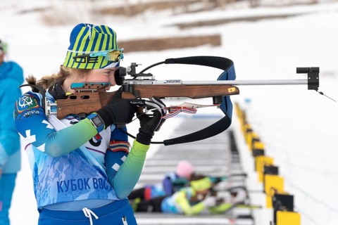 Sportswoman biathlete Legostaeva Anastasia rifle shooting in standing position. Biathlete in