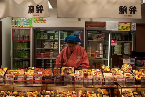 23 Dec 2017, Kyoto, Japan, Asia, A woman sells ready meals and drinks in a train station kiosk in